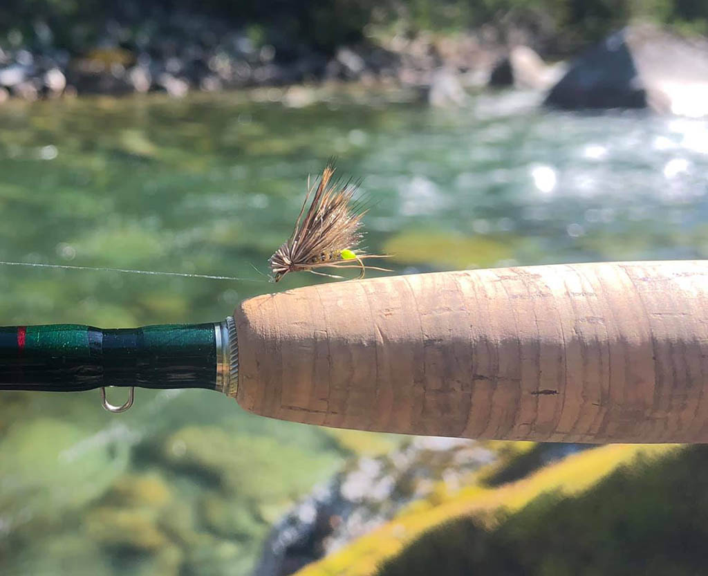 Egg-laying caddis fly pattern with a river backdrop.